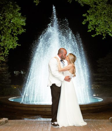 bride and groom kissing in front of fountain at vip
