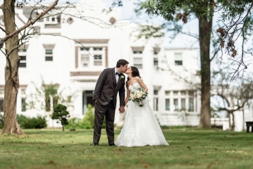 bride and groom kissing on grass on vip estate