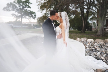 bride kissing groom at water fountain