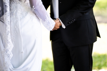closeup of bride and groom holding hands