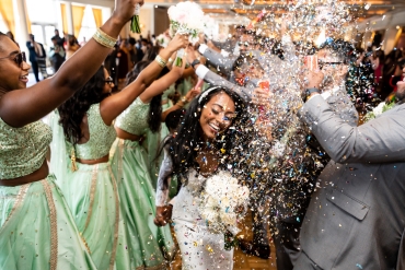 bride getting confetti thrown in air in celebration