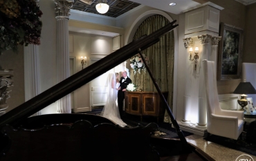 couple having a moment behind grand piano