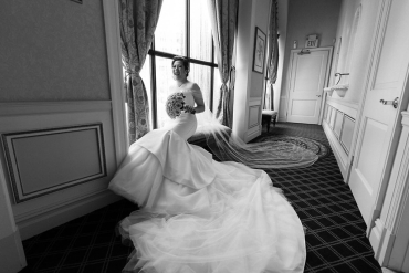 bride sitting in front of vip windows with dress spread out
