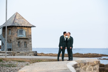 male couple kissing by water