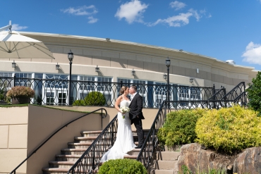 bride and groom kissing on outdoor patio steps