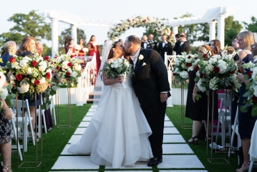 Bride and Groom kissing while walking down isle