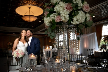 bride and groom posting behind beautiful centerpiece 