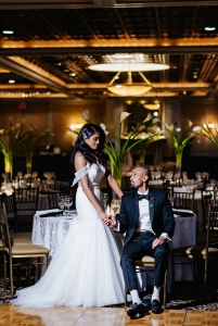 bride standing over groom in chair