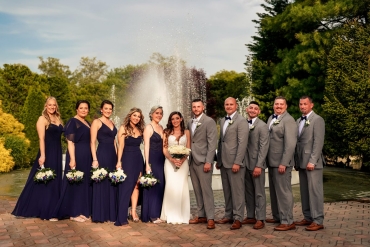 bridal party posing in front of water fountain