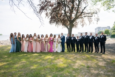 bridal party of 22 posing in front of tree