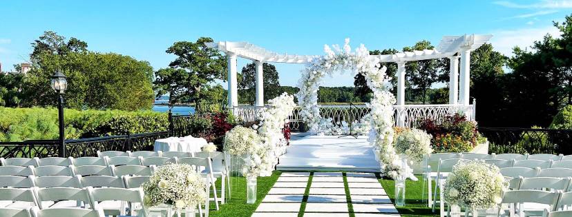 Ceremony Pergola setup with beautiful flowers and white chairs