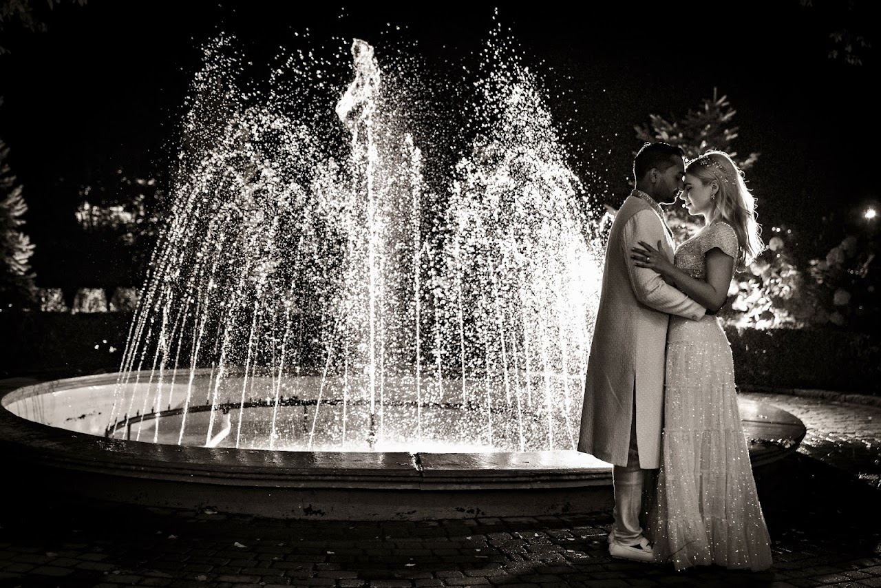 newlyweds dancing in front of water fountain